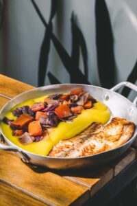 Tilápia orgânica com purê de mandioquinha com tomates assados e azeitona