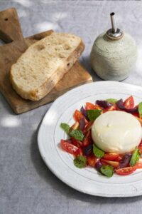 burrata com tomatinho cereja, azeitona preta e hortelã com pão de fermentação natural, orgânico