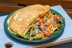 omeletão suflê recheado com tilápia, azeitona preta e salsinha com salada