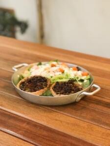 torta de 2 texturas de berinjela com mix de folhas verdes, grão de bico, cenoura assada, erva doce e molho de yogurt