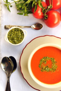 Sopa de tomate servida com pesto de manjericão